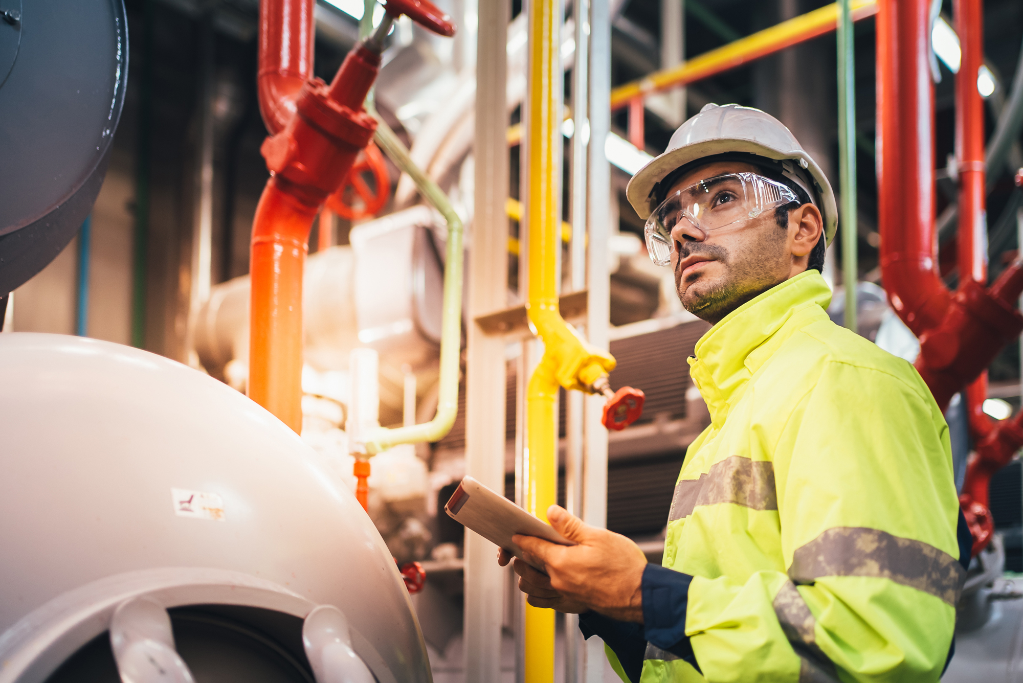 Male Worker in Yellow Safety Jacket Holding Tablet